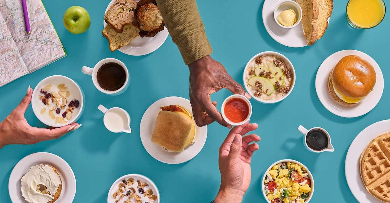 A selection of breakfast dishes set against a blue-green background