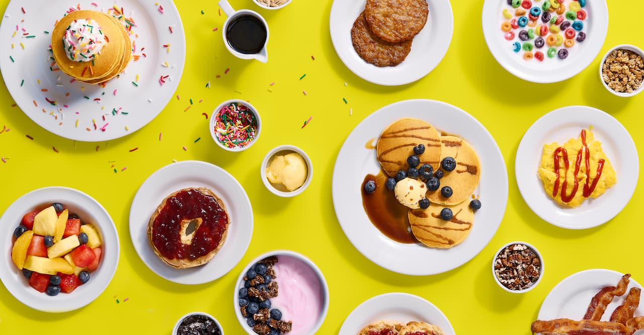 A selection of breakfast dishes set above a yellow background