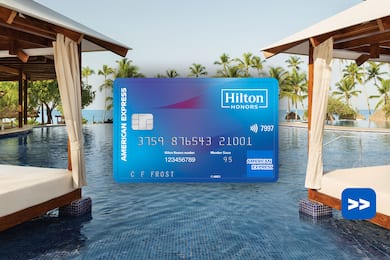 Hilton Honors American Express Card in front of a swimming pool background