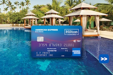 Hilton Honors American Express Business Card in front of a swimming pool background